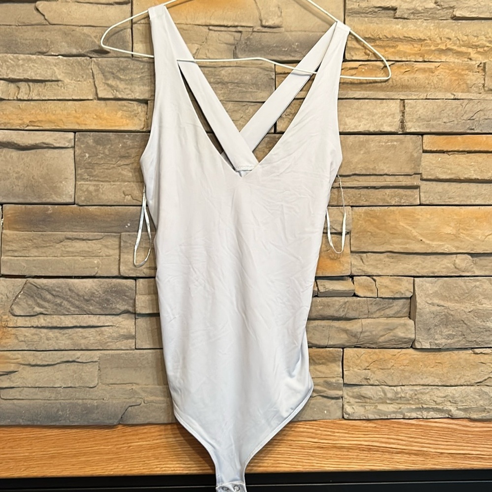Body suit with crossed straps